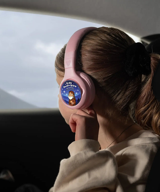 A child wearing ONANOFF pink Disney StoryPhones with Kids Audio Bible Old Testament StoryShield, listening to stories about Abraham and Issac. The girl looks out a car window at a distant mountain.