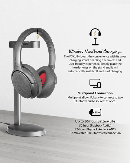 A pair of dusk gray ONANOFF Fokus+ wireless headphones with a red inner ear pad sits on a gray wireless charging stand. Text describes features: wireless headband charging, connect to 2 devices with multipoint connection, and up to 50-hour battery life.